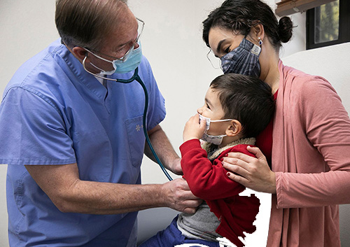 Jeffrey S. Kaplan, MD. looking at a child with her mother in a doctor office.