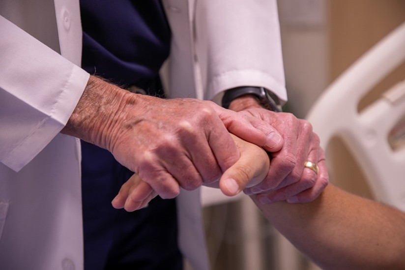 Image of a doctor holding a person's hand.